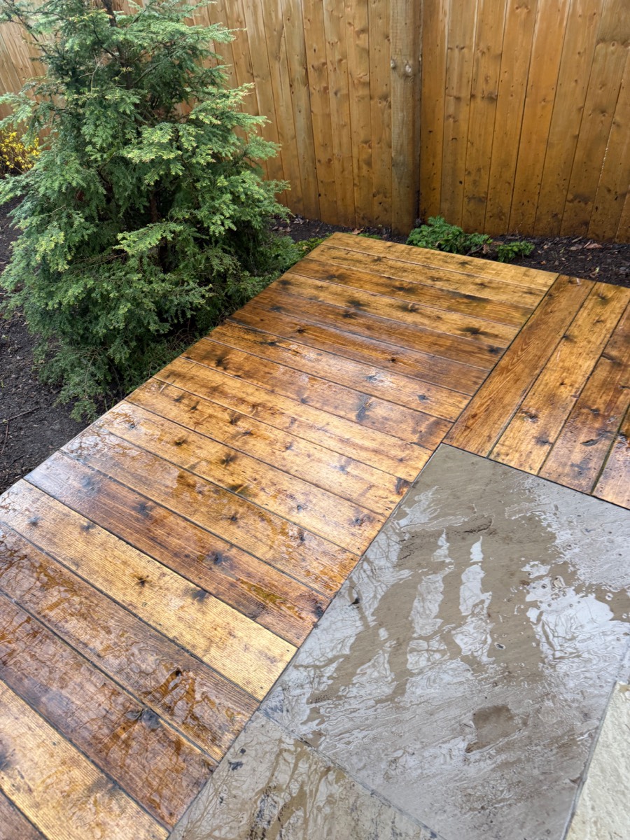 Clean deck area with fresh mulched beds after cleanup